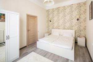 利維夫的住宿－#1 APARTMENT，卧室配有白色的床和墙壁
