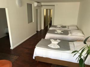 3 Betten in einem Zimmer mit weiß und grau in der Unterkunft Durty Nelly's Pub in Prag