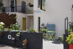 a building with potted plants and a table at Hotel Epi d'Or in Angoulême