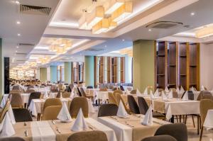 - une salle de banquet avec des tables et des chaises blanches dans l'établissement Unique - Resort and SPA, à Ohrid
