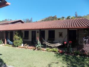 una casa con techo rojo y patio en Pousada Canto Nosso en São Pedro da Serra