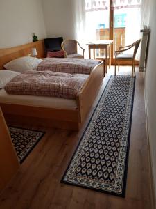 a bedroom with two beds and a rug at Gästehaus Schrötter in Lam