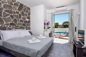 a bedroom with a bed and a view of a pool at Sun Springs Suites in Kamari