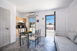 eine Küche und ein Esszimmer mit Tisch und Stühlen in der Unterkunft Sun Springs Suites in Kamari