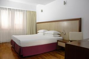 Habitación de hotel con cama grande y escritorio. en City5 ROOMS & SUITES by LSA, en Skopje