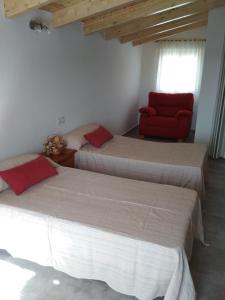 サン・ハビエルにあるBonito loft abuhardillado cerca de la playa, 40 m2のベッドルーム1室(ベッド3台、赤い椅子付)