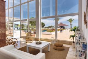 un soggiorno con divano bianco e tavolo di Garden Playanatural - Adults Only a El Rompido