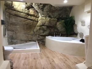 a bathroom with a stone wall and a bath tub at Respirar in Peniscola