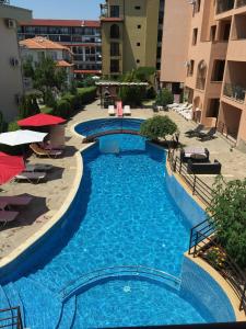 una gran piscina azul en medio de un edificio en Dom-El Real Apartments 4 - Sveti Vlas, en Sveti Vlas