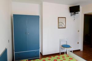 a room with a blue cabinet and a chair and a rug at Appartamenti Padoan in Sottomarina