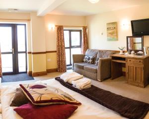 een woonkamer met een bed en een bank bij Fernhill Bed and Breakfast in Rochdale