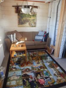 uma sala de estar com um sofá e um tapete em Stallet B&B em Köping