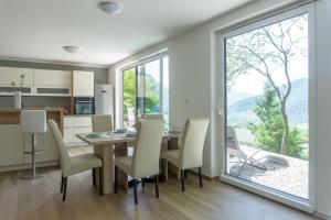 a dining room with a table and chairs and a large window at Nature View House with Sauna in Tolmin