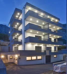 a tall white building with lights on it at Holiday Home Ivan in Makarska