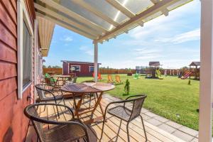 a patio with tables and chairs and a playground at Ardonas in Šventoji