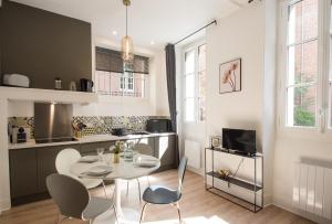 eine Küche und ein Esszimmer mit einem Tisch und Stühlen in der Unterkunft La Dame du Taur by Cocoonr in Toulouse