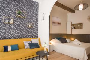 een slaapkamer met 2 bedden en een gele bank bij La Dame du Taur by Cocoonr in Toulouse