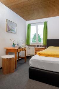 リギ・カルトバートにあるホテル レストラン アルピナのベッドルーム1室(ベッド1台、デスク、デスク付)