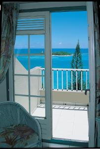 a room with a view of the ocean from a balcony at Résidence Turquoise Guadeloupe - Vue mer et lagon in Le Gosier