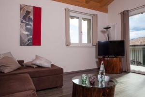 Una sala de estar con un sofá y un televisor de pantalla plana. en Appartamento Campiano, en Malcesine
