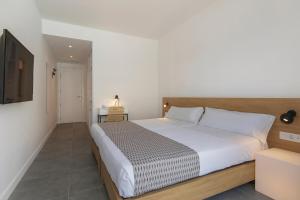 a bedroom with a large bed and a television at HM Martinique in Magaluf