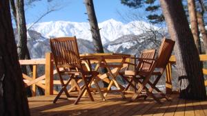 Una mesa y sillas de madera en una terraza con vistas a las montañas. en Earl Grey, en Hakuba 28 fotos más