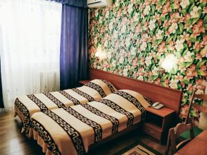 アナパにあるHotel Chaikaの花の壁が特徴の客室で、ベッド2台が備わります。