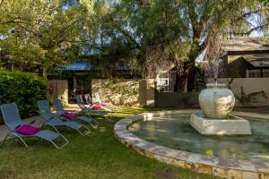 a group of chairs and a fountain in a yard at Village Boutique Hotel in Otjiwarongo