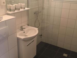 a white bathroom with a sink and a shower at Hygge House Nr. 413 in Andijk +22 photos