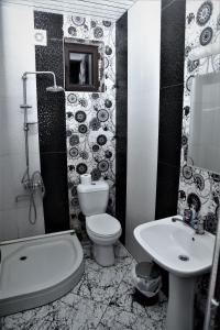 a black and white bathroom with a toilet and a sink at White House Mtskheta in Mtskheta