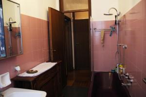 uma casa de banho com um lavatório e um chuveiro com azulejos cor-de-rosa em big room in Milano center em Milão