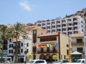 ein großes Gebäude mit einem Uhrturm in einer Stadt in der Unterkunft Apartamentos Quintero – Adults Only in San Sebastián de la Gomera