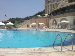 a large swimming pool in front of a building at Lidya Sardes Hotel Thermal & SPA in Salihli