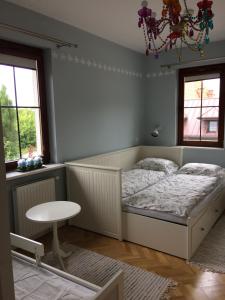 a bedroom with a bed and a table and window at Apartament Rodzinny in Kazimierz Dolny