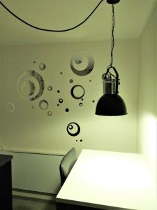 ein schwarzes Licht, das über einem Tisch in einem Zimmer hängt in der Unterkunft Apartment Hof-Bayern in Hof