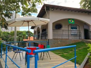 um parque infantil em frente a uma casa com um guarda-chuva em Lodge Hostel Piracicaba em Piracicaba