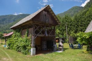 a barn with a table and chairs in a yard at Apartment House Andrej in Bohinj
