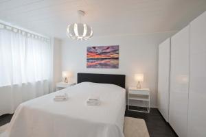 a white bedroom with a white bed and two tables at Arctic Suite in Rovaniemi