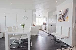 a white dining room with a white table and chairs at Arctic Suite in Rovaniemi