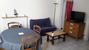Saint-Amand-en-PuisayeにあるPetite maison aux volets bleusのリビングルーム(テーブル、青いソファ付)