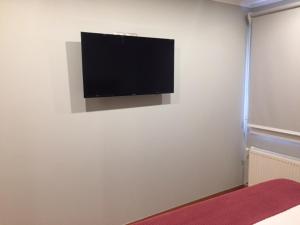 a flat screen tv hanging on a white wall at Casa Bellavista Hotel in Santiago