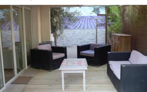 a patio with couches and a coffee table on a patio at chemin neuf jardin in Gréoux-les-Bains