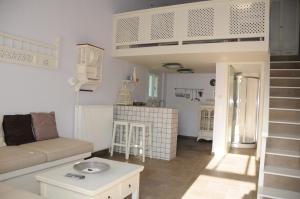 ein Wohnzimmer mit Sofa und Hochbett in der Unterkunft Crisio Studios in Skyros