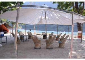 Shivpuri的住宿－Ubud Riverside Camps，海滩帐篷下的一组桌椅