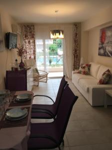 een woonkamer met een bank en een tafel bij Lovely Appartments Lygia Korinthias in Liyiá