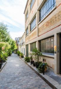 a cobblestone street in front of a building at Veeve - Cosy Gambetta in Paris