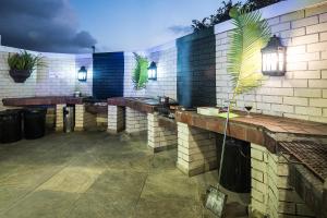 馬蓋特的住宿－First Group La Cote D'Azur，砖墙上长凳和植物的酒吧