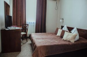 a hotel room with a bed and a television at JJ Hotel in Vynohradiv