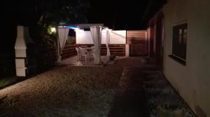 un patio notturno con tavolo e sedie di Il Piccolo Rifugio - L'Angoletto a Palidoro