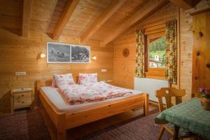 ein Schlafzimmer mit einem Bett in einer Holzhütte in der Unterkunft Haus Panoramablick in Kals am Großglockner